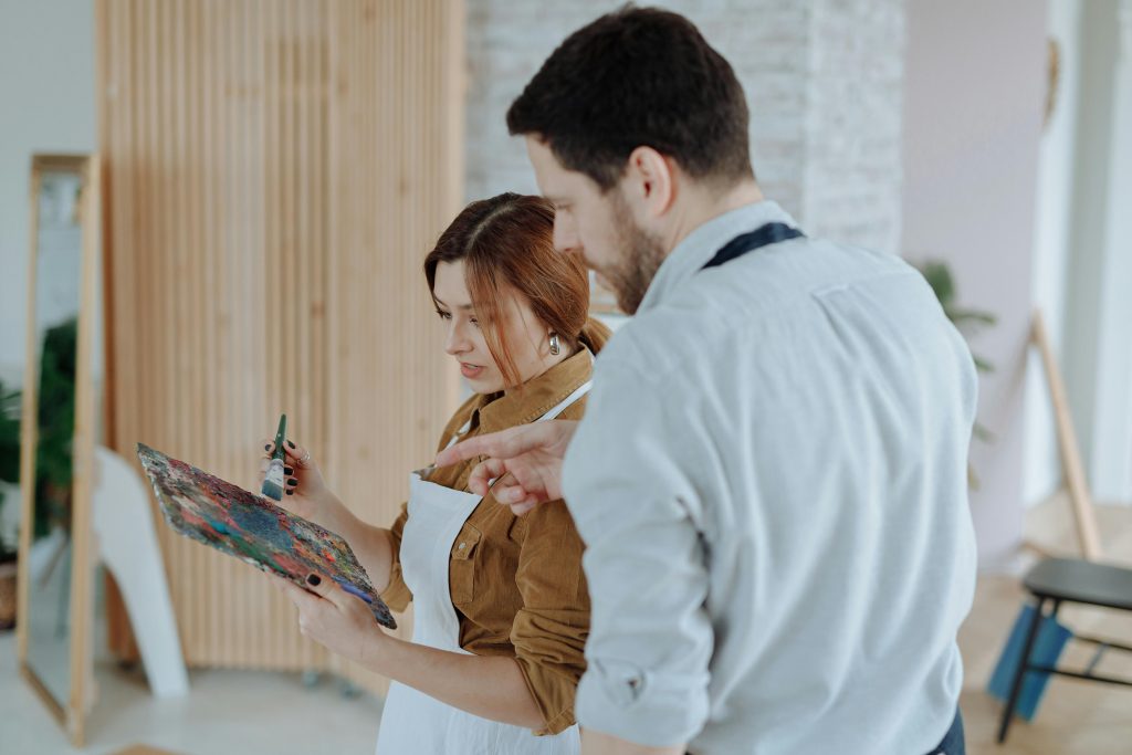 Man and woman collaborating in a creative indoor art lesson, using a color palette. digital art techniques. digital and advanced art tutorial.